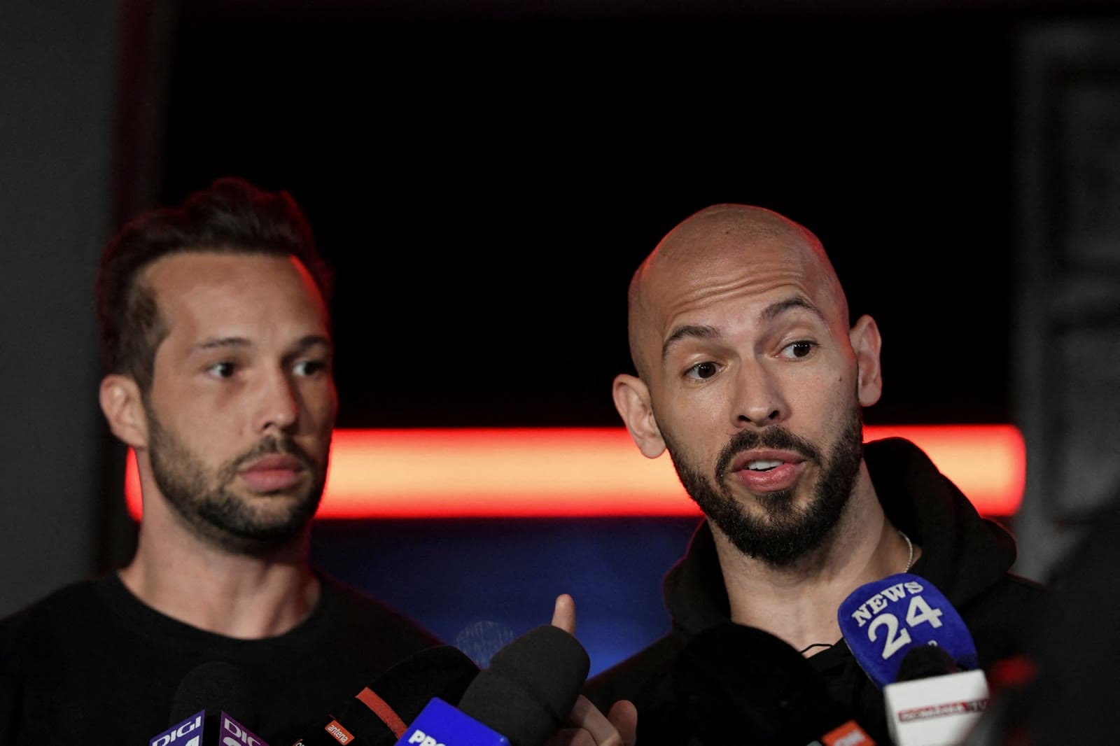 Andrew Tate and Tristan Tate speaking to reporters in Romania