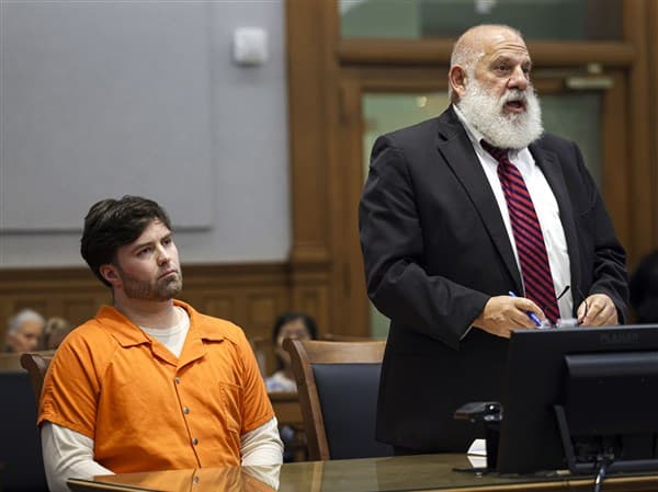 Jonathan Schmidt seated in court beside his lawyer